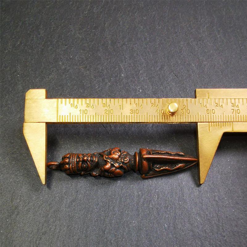 This vintage Phurba pendant was collected from Rega Monastery(Baiyu,Tibet),handmade of copper. It has a statue of Vajrapani on the top and a phurba on the lower part, measuring about 2.36 inches by 0.47 inch.