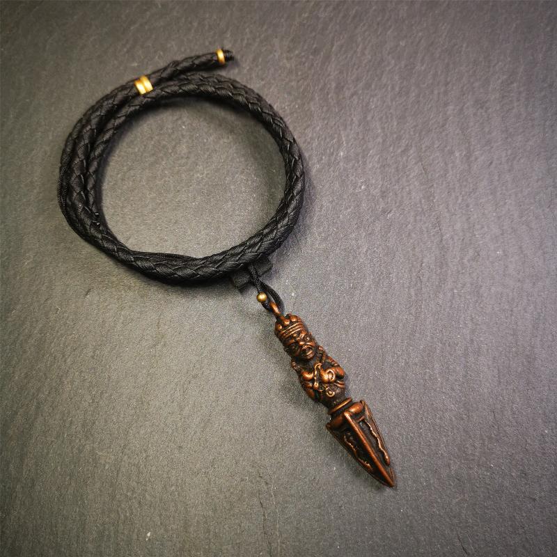 This vintage Phurba pendant was collected from Rega Monastery(Baiyu,Tibet),handmade of copper. It has a statue of Vajrapani on the top and a phurba on the lower part, measuring about 2.36 inches by 0.47 inch.