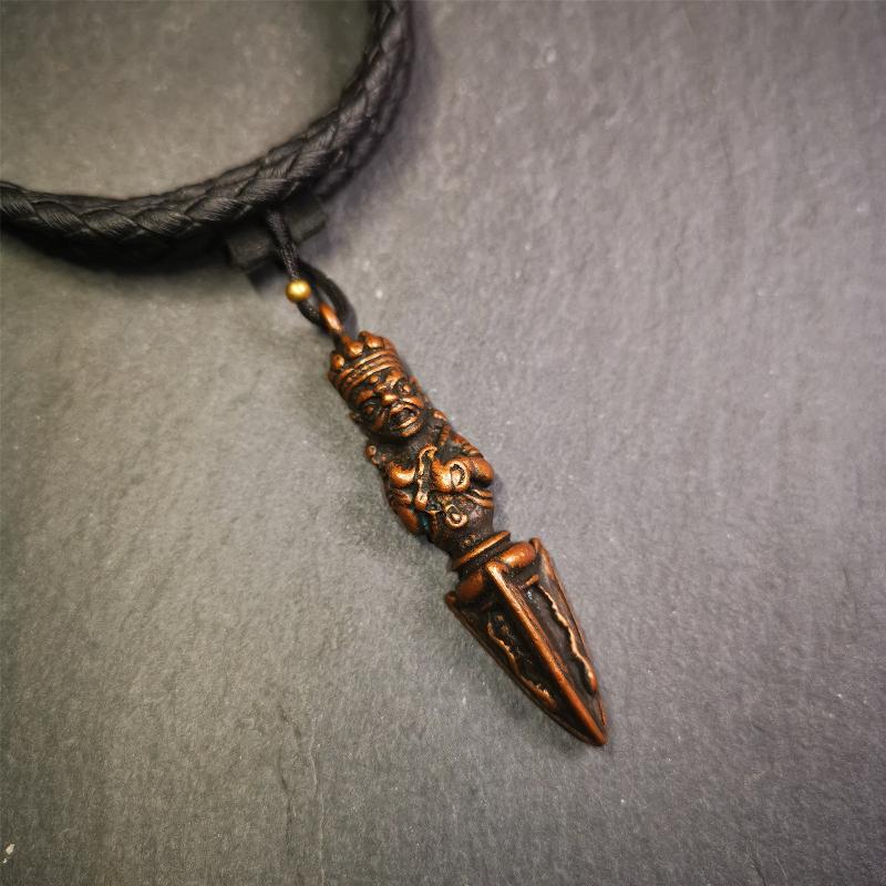 This vintage Phurba pendant was collected from Rega Monastery(Baiyu,Tibet),handmade of copper. It has a statue of Vajrapani on the top and a phurba on the lower part, measuring about 2.36 inches by 0.47 inch.