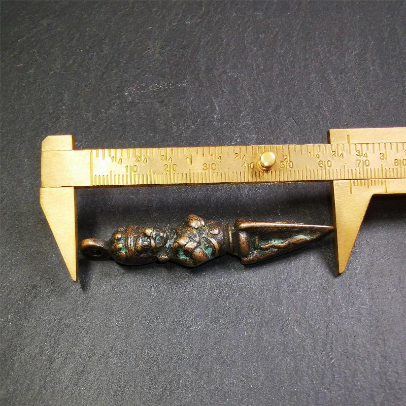This vintage Phurba pendant was collected from Rega Monastery(Baiyu,Tibet),handmade of copper. It has a statue of Vajrapani on the top and a phurba on the lower part, measuring about 2.36 inches by 0.47 inch.