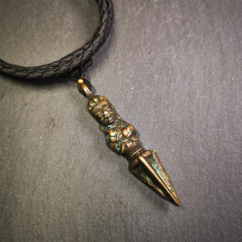 This vintage Phurba pendant was collected from Rega Monastery(Baiyu,Tibet),handmade of copper. It has a statue of Vajrapani on the top and a phurba on the lower part, measuring about 2.36 inches by 0.47 inch.