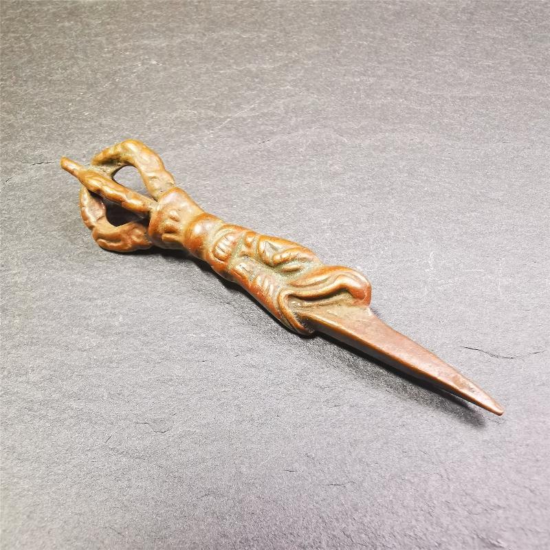 This vintage Phurba pendant was collected from gengqing Monastery(Derge,Tibet),handmade of copper. It is total 2.6 inches,brown color,on top of it is a dragon, the tail of the dragon is half vajra, from the dragon's mouth comes a phurba.