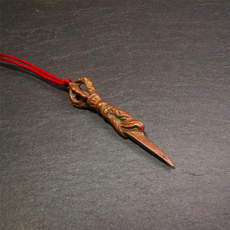 This vintage Phurba pendant was collected from gengqing Monastery(Derge,Tibet),handmade of copper. It is total 2.6 inches,brown color,on top of it is a dragon, the tail of the dragon is half vajra, from the dragon's mouth comes a phurba.