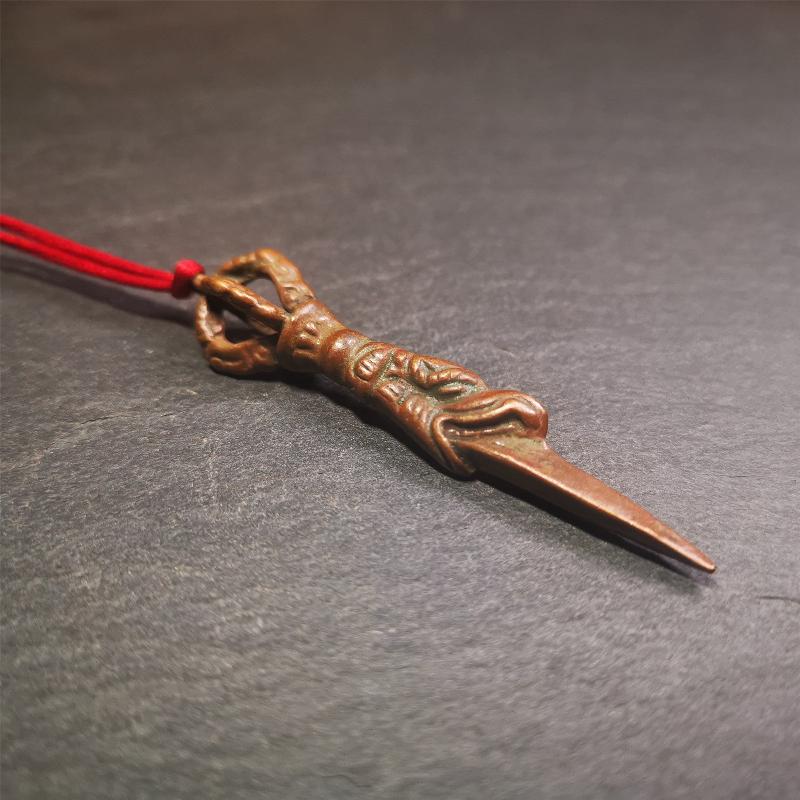 This vintage Phurba pendant was collected from gengqing Monastery(Derge,Tibet),handmade of copper. It is total 2.6 inches,brown color,on top of it is a dragon, the tail of the dragon is half vajra, from the dragon's mouth comes a phurba.
