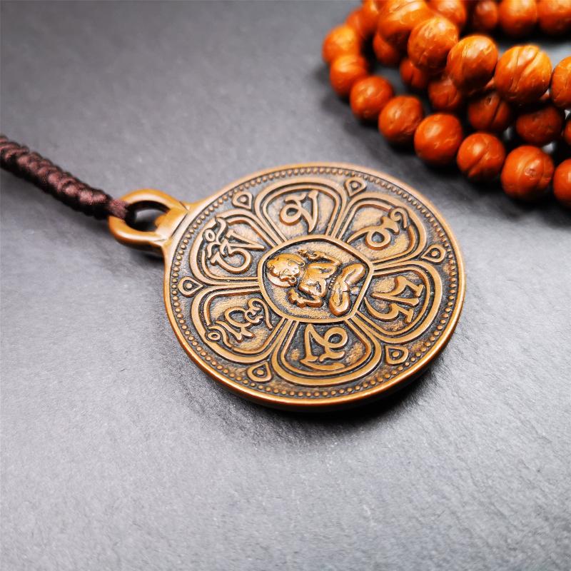 This OM badge amulet was collected from Jiegu Monastery Tibet.It is made of copper,diameter is 1.65 inches,Chenrezig is on the center, carved with Tibetan Letter ,Om Mani Padme Hum mantra,the letter on the back is Mind