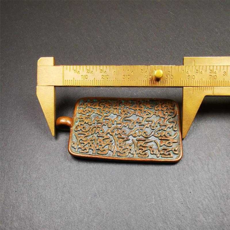 This badge is made by Tibetan craftsmen from Hepo Town, Baiyu County, the birthplace of the famous Tibetan handicrafts. It is made of copper, 2.44 × 1.42 inches. The front is the OM mantra and the back is body, speech, and mind.