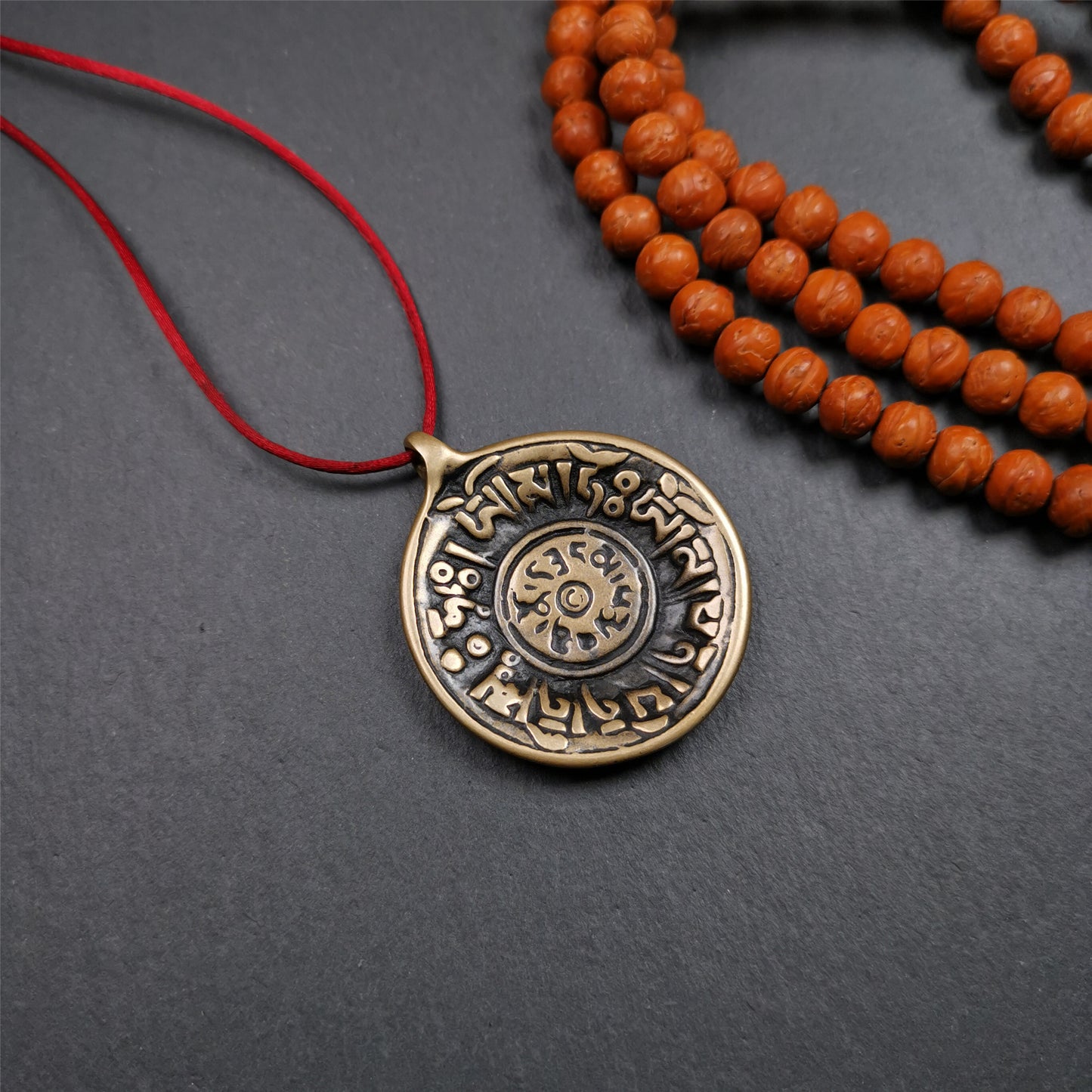 This Om badge amulet was collected from Yushu City Tibet,about 50 years old. It is round shape,made of lima brass, 1.58 inches,carved with mantra of chenrezig OM MANI PADME HUM. You can make it into a necklace, or a keychain, pendant
