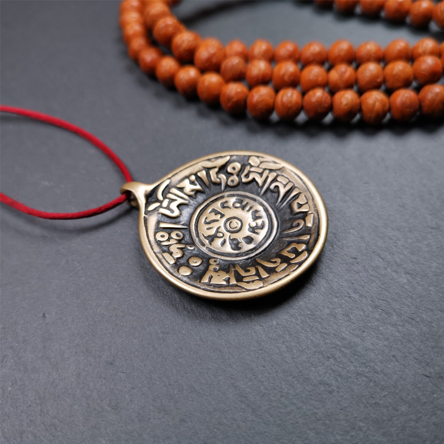 This Om badge amulet was collected from Yushu City Tibet,about 50 years old. It is round shape,made of lima brass, 1.58 inches,carved with mantra of chenrezig OM MANI PADME HUM. You can make it into a necklace, or a keychain, pendant