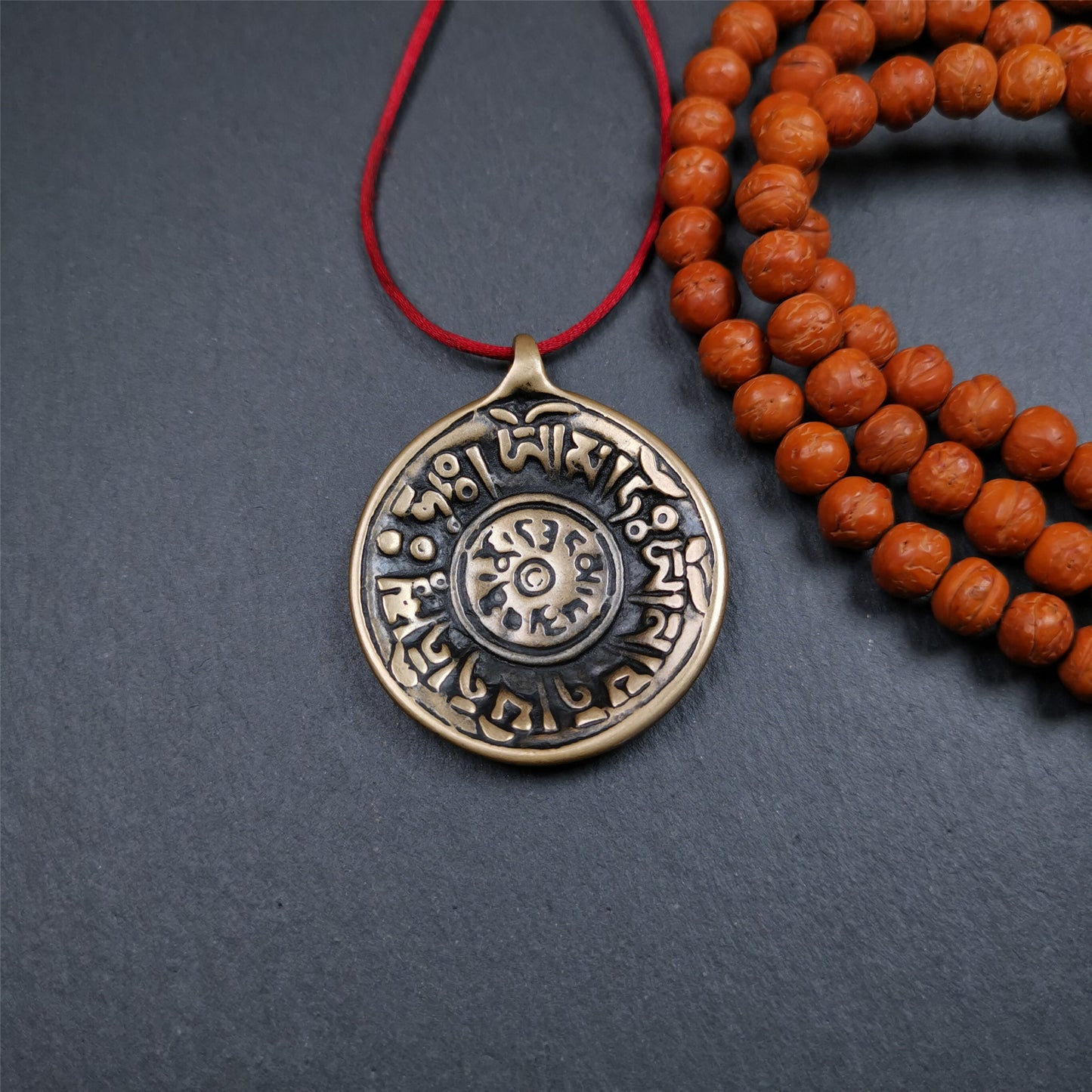 This Om badge amulet was collected from Yushu City Tibet,about 50 years old. It is round shape,made of lima brass, 1.58 inches,carved with mantra of chenrezig OM MANI PADME HUM. You can make it into a necklace, or a keychain, pendant