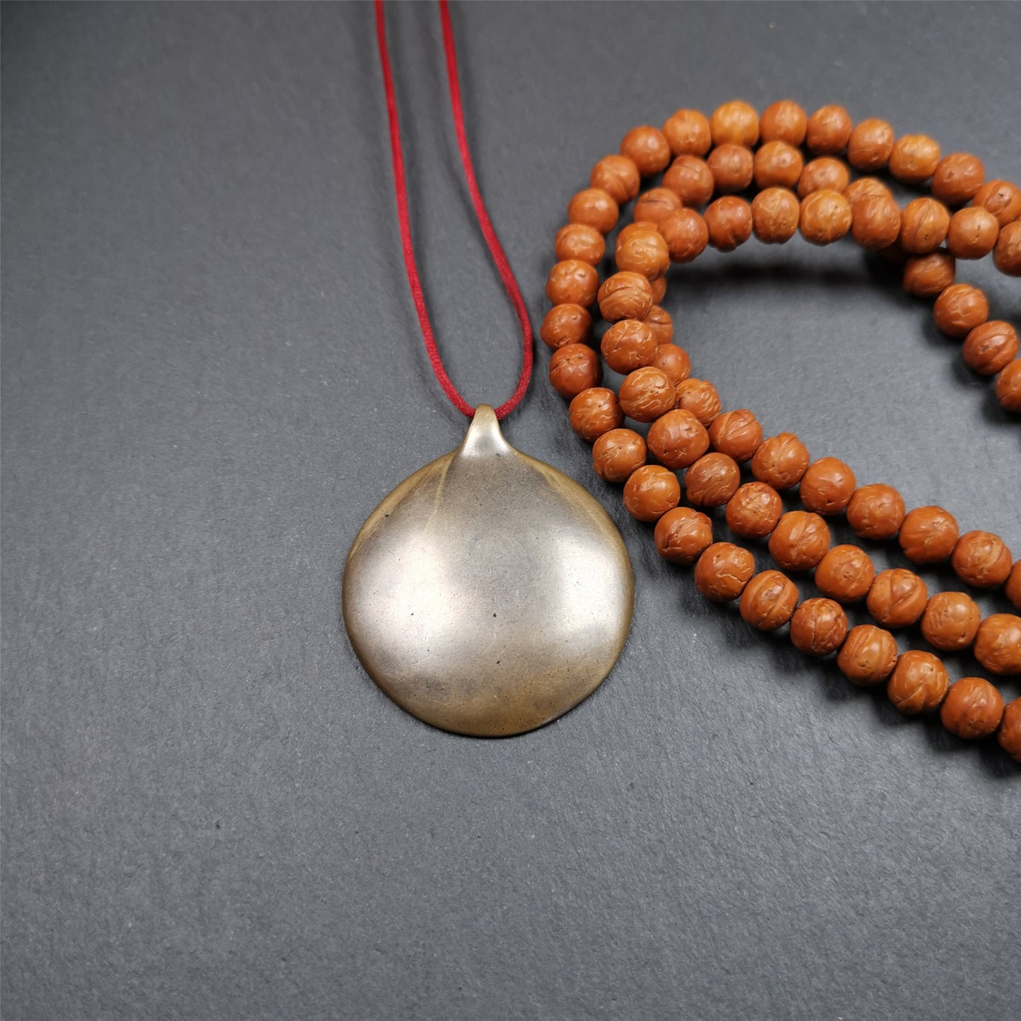 This Om badge amulet was collected from Yushu City Tibet,about 50 years old. It is round shape,made of lima brass, 1.58 inches,carved with mantra of chenrezig OM MANI PADME HUM. You can make it into a necklace, or a keychain, pendant