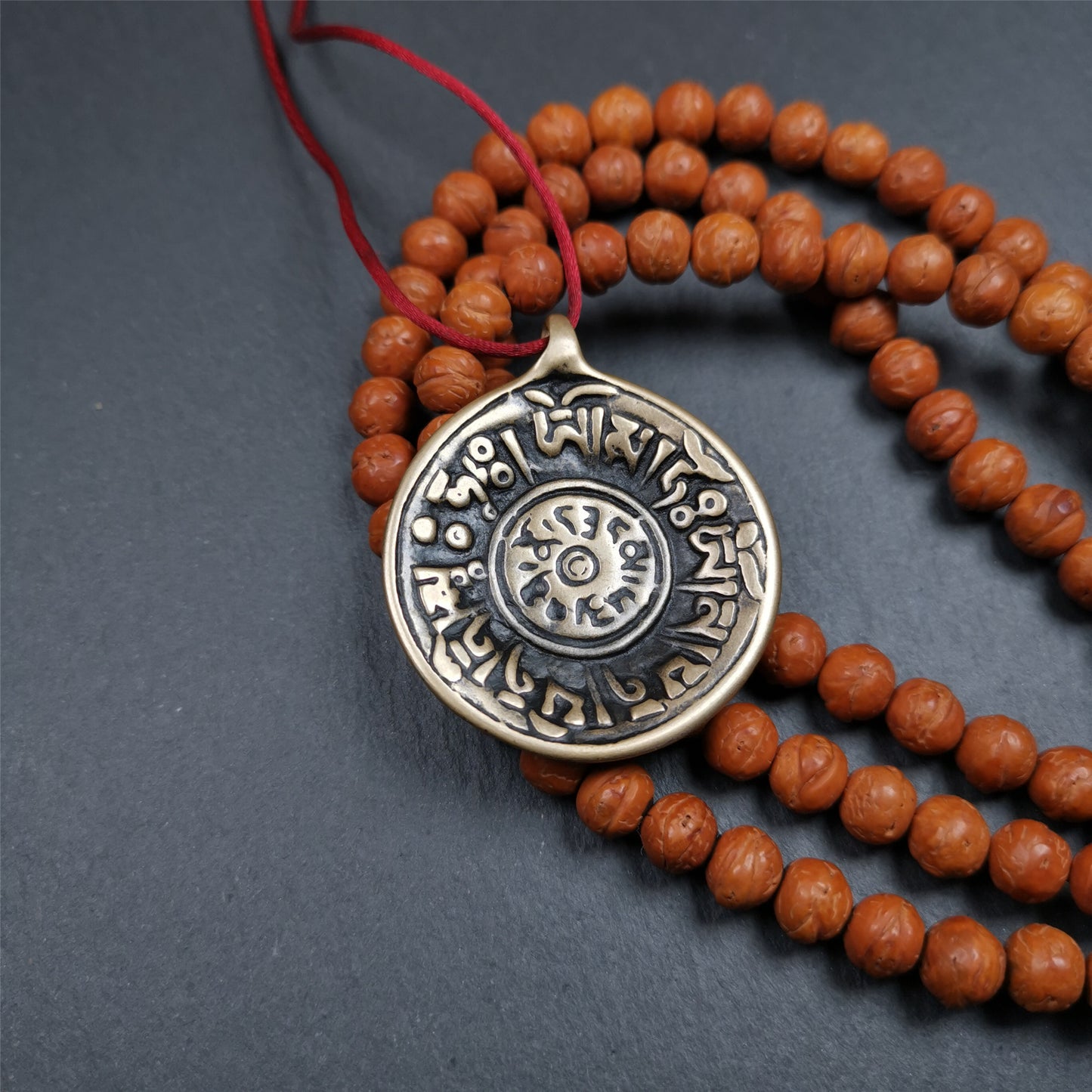 This Om badge amulet was collected from Yushu City Tibet,about 50 years old. It is round shape,made of lima brass, 1.58 inches,carved with mantra of chenrezig OM MANI PADME HUM. You can make it into a necklace, or a keychain, pendant