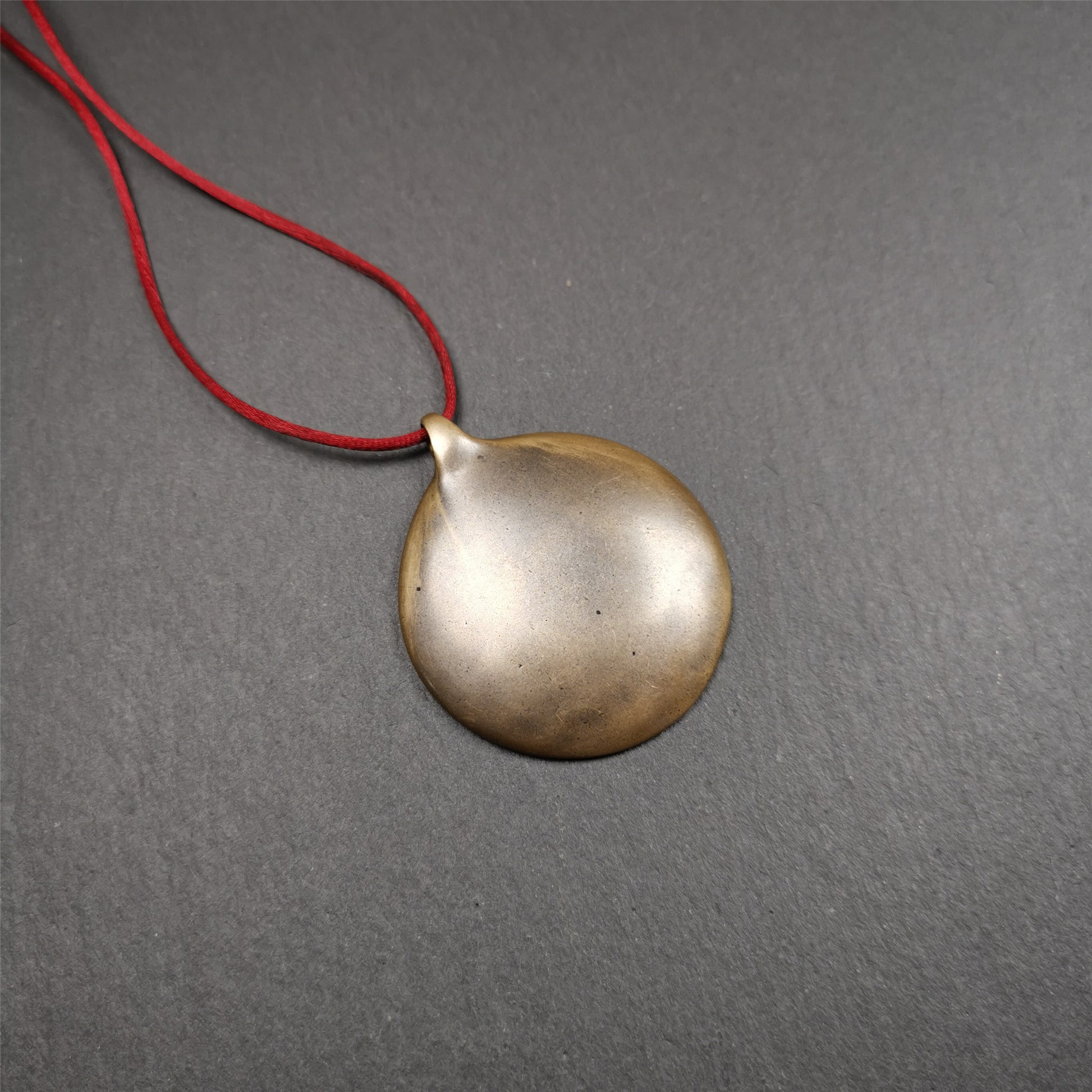 This Om badge amulet was collected from Yushu City Tibet,about 50 years old. It is round shape,made of lima brass, 1.58 inches,carved with mantra of chenrezig OM MANI PADME HUM. You can make it into a necklace, or a keychain, pendant