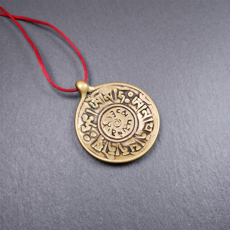 This Om badge amulet was collected from Yushu City Tibet,about 50 years old. It is round shape,made of lima brass, 1.65 inches,carved with mantra of chenrezig OM MANI PADME HUM. You can make it into a necklace, or a keychain, pendant