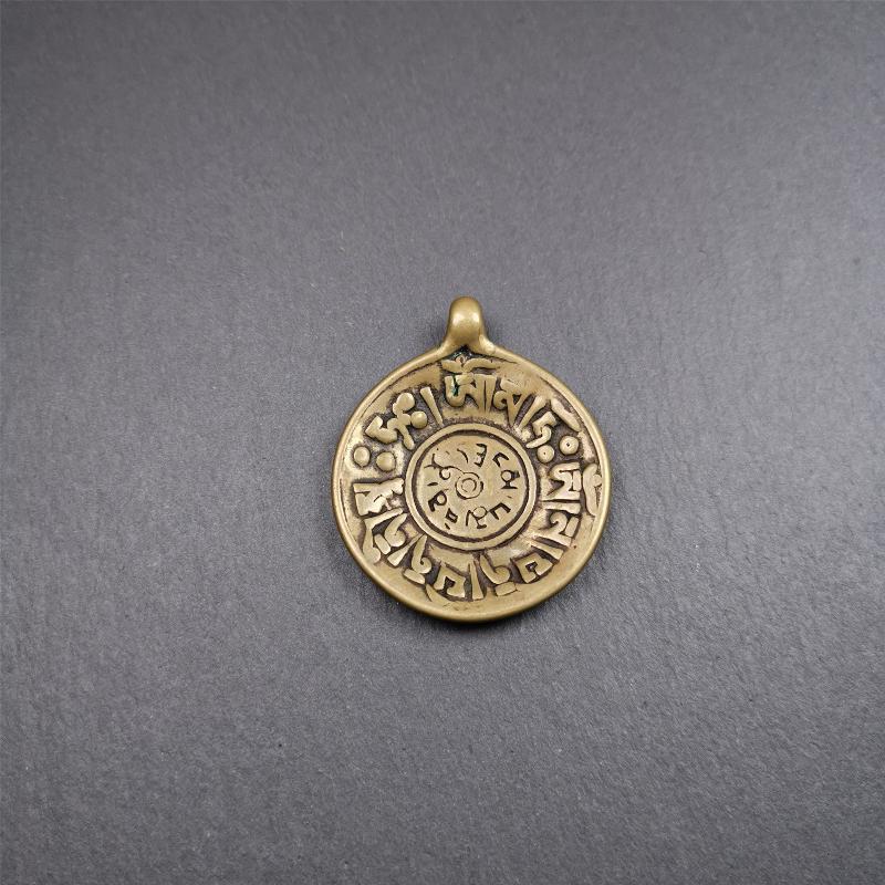 This Om badge amulet was collected from Yushu City Tibet,about 50 years old. It is round shape,made of lima brass, 1.65 inches,carved with mantra of chenrezig OM MANI PADME HUM. You can make it into a necklace, or a keychain, pendant