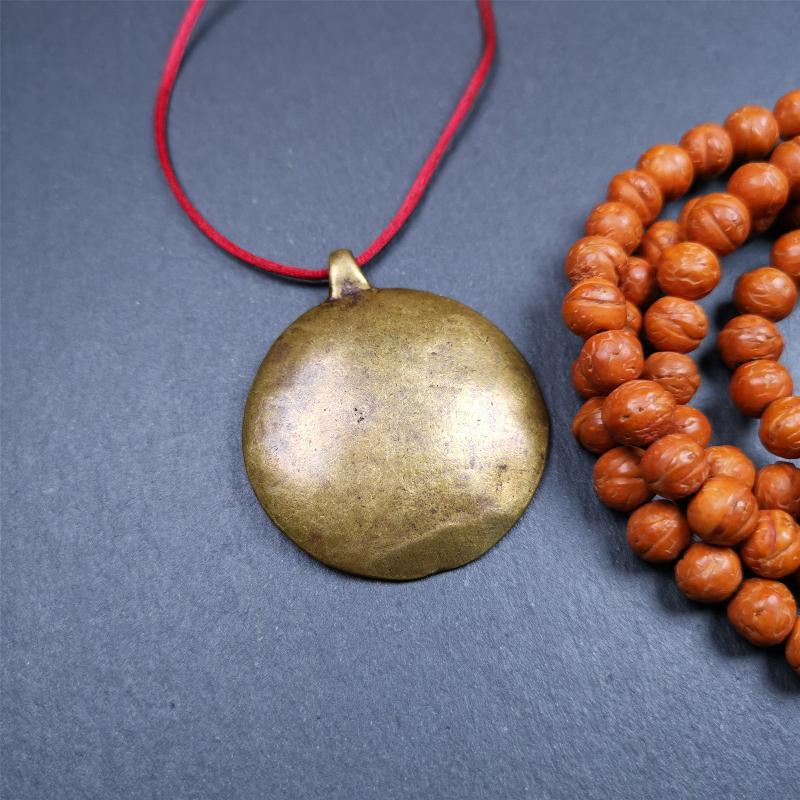 This Longevity Badge was handmade by Tibetan craftsmen and come from Hepo Town, Baiyu County, Tibet. It is made of brass,round shape,the theme is the god of longevity,surrounded by the symbols of Ashtamangala.