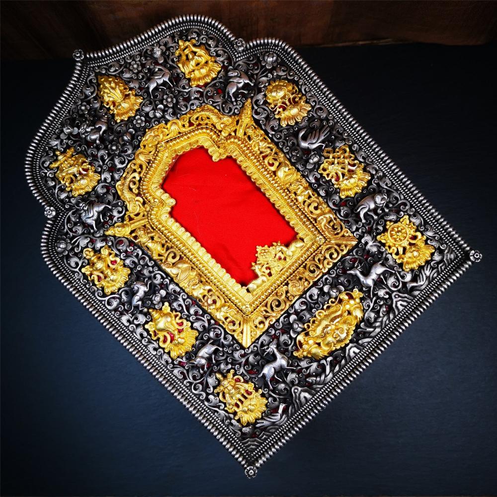 This large Gau shrine was handcrafted by Tibetan artisans from Hepo Township, Baiyu County. Each exquisite pattern on it is meticulously hand-carved,and it is embellished with the technique of gold inlay, with pure silver inlaid on the red copper material and gold-plated on the pure silver material.Its theme is Astamangala, and it features 10 mythical creatures traversing a silver-patterned meadow. The interior space of the box is quite spacious, large enough to accommodate a 12 * 8 cm Buddha statue.