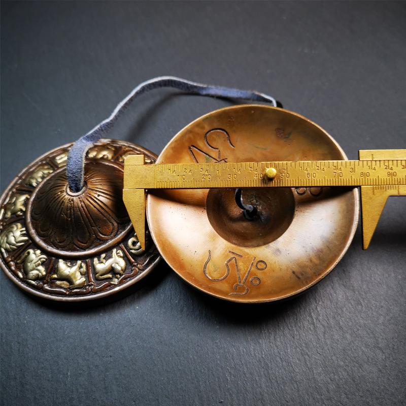 This tingsha bell set was handmade in Nepal,using traditional techniques and materials. It was made of bronze,carved 12 tibetan zodiac pattern,8.3cm diameter,with pure, clear and resonant,good for meditation. Come with tingsha case.