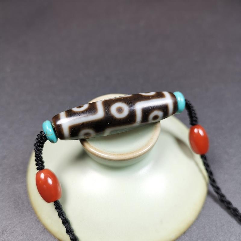 This 9 eyes dzi necklace was hand-woven by Tibetans from Baiyu County, the main bead is a 9 eyed dzi bead, paired with 2 small agate beads and 2 turquoise spacer beads,about 30 years old.