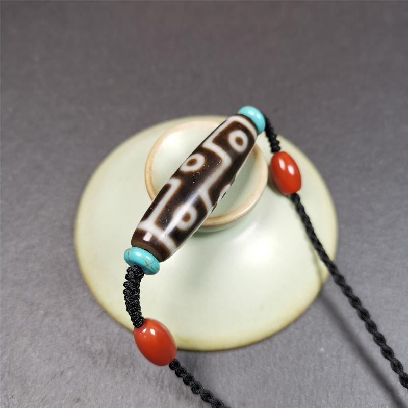 This 9 eyes dzi necklace was hand-woven by Tibetans from Baiyu County, the main bead is a 9 eyed dzi bead, paired with 2 small agate beads and 2 turquoise spacer beads,about 30 years old.