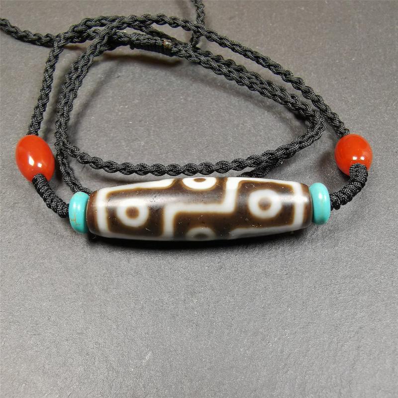 This 9 eyes dzi necklace was hand-woven by Tibetans from Baiyu County, the main bead is a 9 eyed  dzi bead, paired with 2 small agate beads and 2 turquoise spacer beads,about 30 years old.