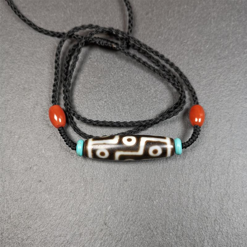 This 9 eyes dzi necklace was hand-woven by Tibetans from Baiyu County, the main bead is a 9 eyed dzi bead, paired with 2 small agate beads and 2 turquoise spacer beads,about 30 years old.