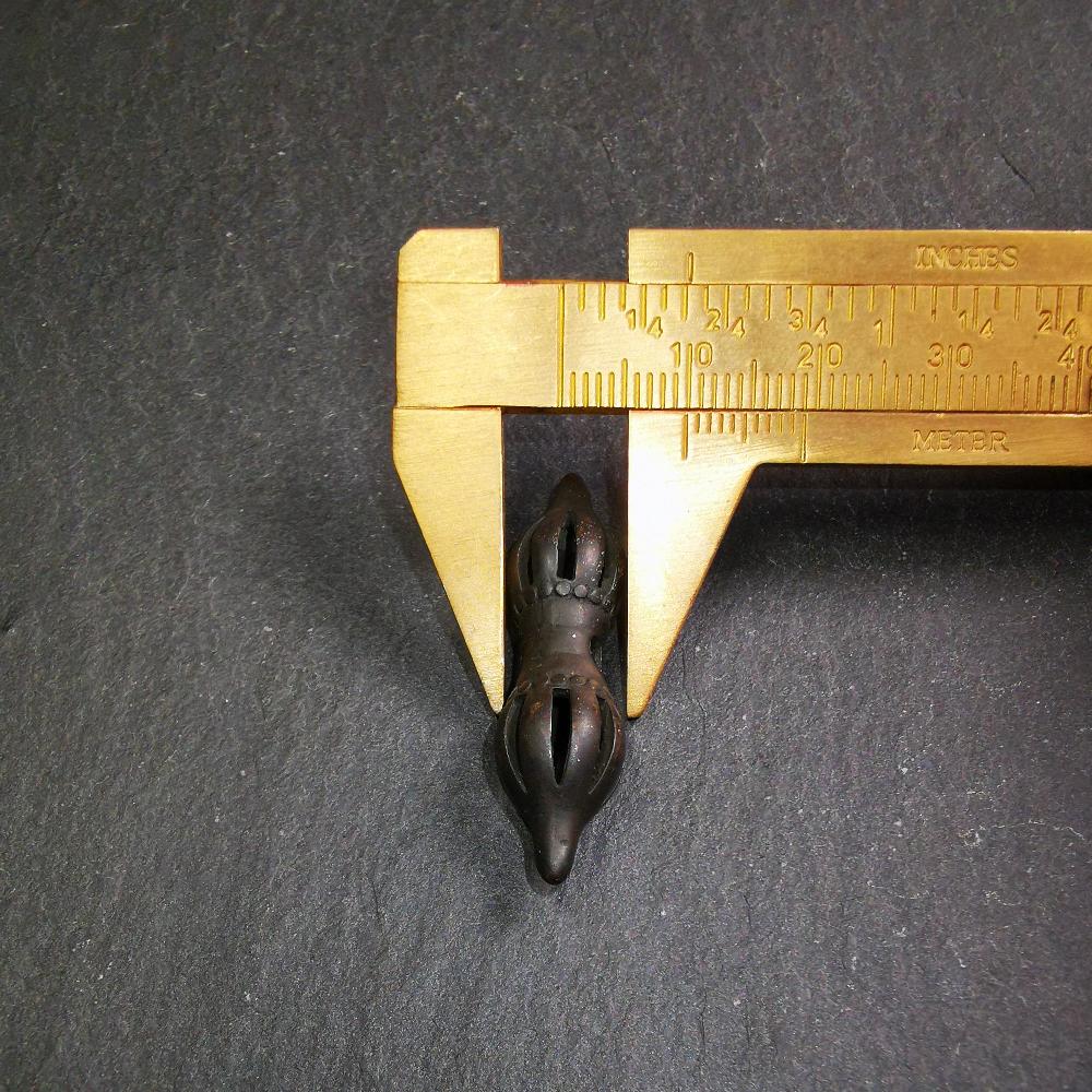 This vajra pendant was handmade by Tibetan craftsmen from Tibet,from Hepo Town, Baiyu County, the birthplace of the famous Tibetan handicrafts. It is nine-pronged vajra,made of brass,black color,1.5 inches length.
