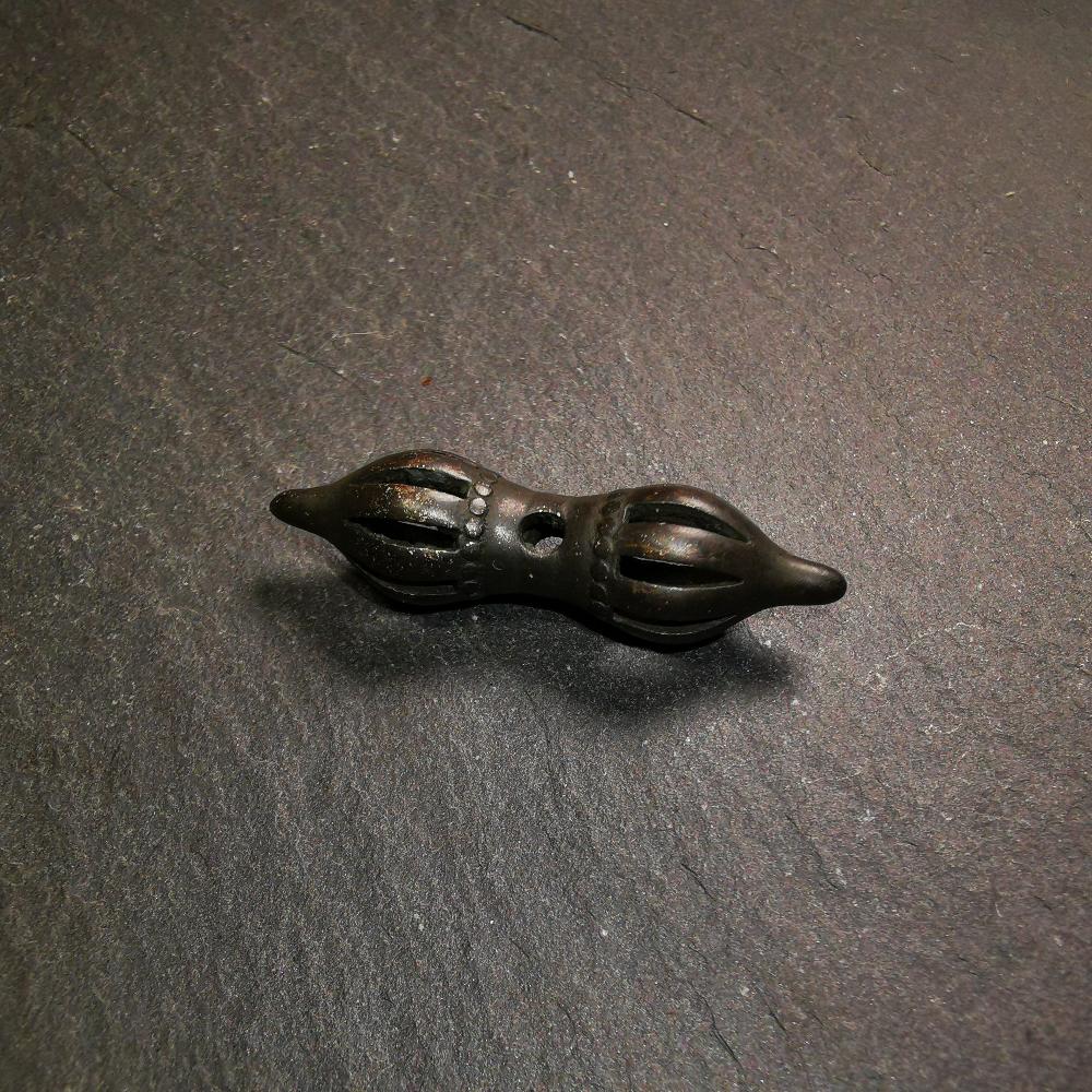 This vajra pendant was handmade by Tibetan craftsmen from Tibet,from Hepo Town, Baiyu County, the birthplace of the famous Tibetan handicrafts. It is nine-pronged vajra,made of brass,black color,1.5 inches length.