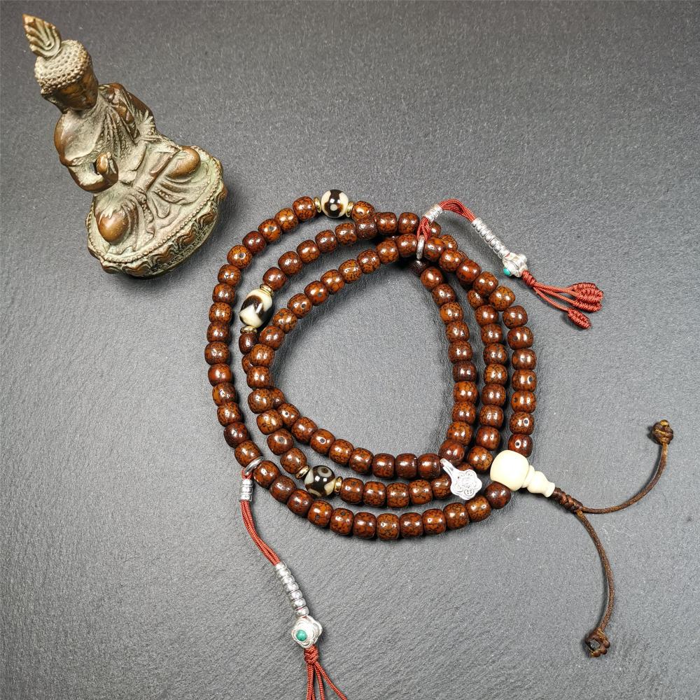 This old lotus seed mala was handmade from tibetan crafts man in Baiyu County,about 30 years old. It's composed of 108 lotus seed beads,then add some dzi beads,1 pair of silver bead counters,and ivory guru bead on i