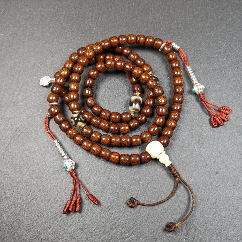 This old lotus seed mala was handmade from tibetan crafts man in Baiyu County,about 30 years old. It's composed of 108 lotus seed beads,then add some dzi beads,1 pair of silver bead counters,and ivory guru bead on i
