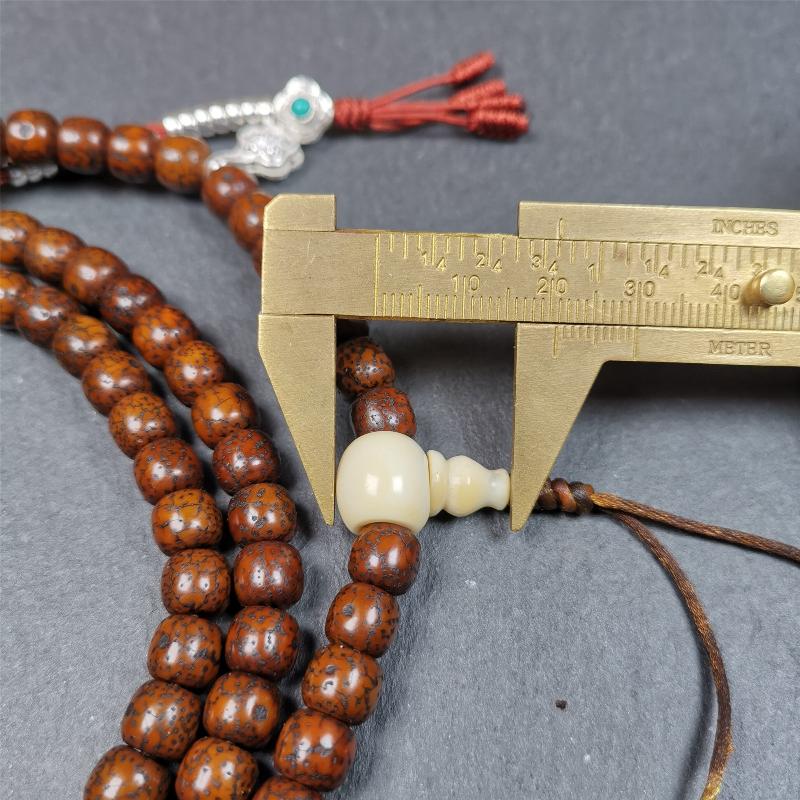 This old lotus seed mala was handmade from tibetan crafts man in Baiyu County,about 30 years old. It's composed of 108 lotus seed beads,then add some dzi beads,1 pair of silver bead counters,and ivory guru bead on i