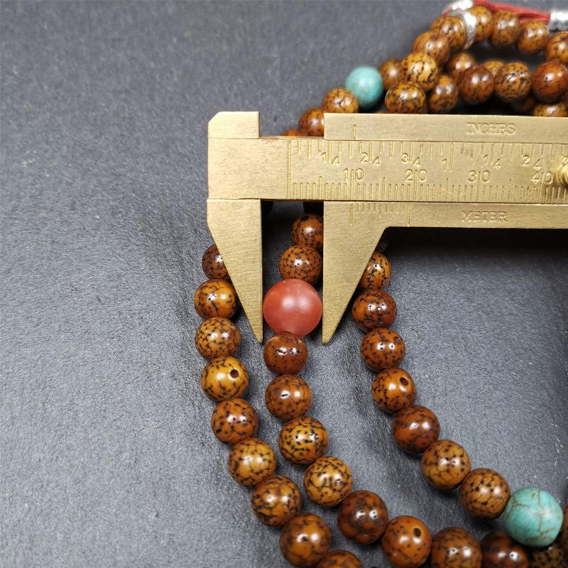 This old lotus seed mala was handmade from tibetan crafts man in Baiyu County,about 30 years old. It's composed of 108 pcs 7mm lotus seed beads,then add some old agate,turquoise beads,1 pair of silver bead counters,and bone guru bead on it.