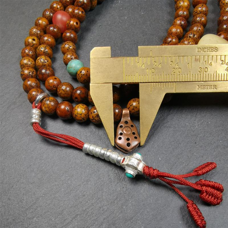 This old lotus seed mala was handmade from tibetan crafts man in Baiyu County,about 30 years old. It's composed of 108 pcs 7mm lotus seed beads,then add some old agate,turquoise beads,1 pair of silver bead counters,and bone guru bead on it.