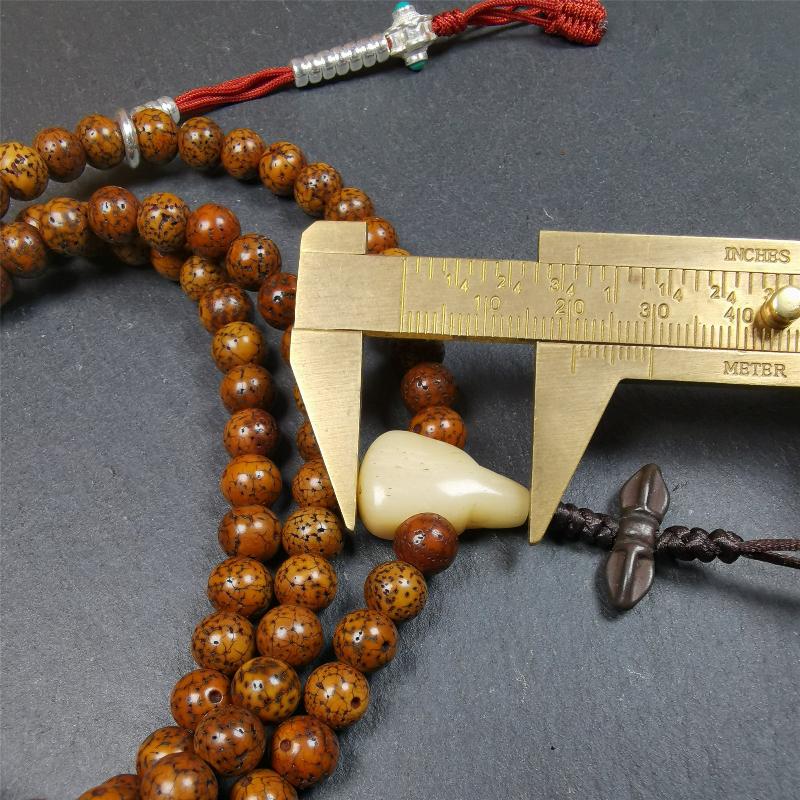 This old lotus seed mala was handmade from tibetan crafts man in Baiyu County,about 30 years old. It's composed of 108 pcs 7mm lotus seed beads,then add some old agate,turquoise beads,1 pair of silver bead counters,and bone guru bead on it.