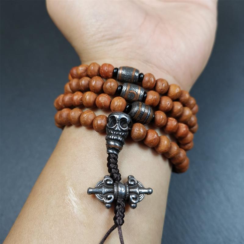 This bodhi beads mala is made by Tibetan craftsmen and come from Hepo Town, Baiyu County, the birthplace of the famous Tibetan handicrafts,about 30 years old, hold and blessed by a lama in Baiyu Monastery. It is composed of 108 bodhi seed beads, and is equipped with 3 cold iron dzi beads, cold iron bead counters are installed on both sides, 1 mani jewel bead clip,and finally consists a skull guru bead and vajra on the end, very elegant.