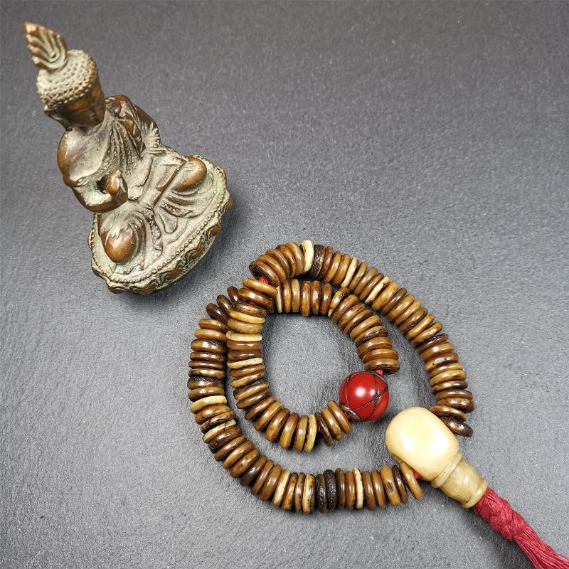 This bone carved mala beads is made by Tibetan craftsmen,about 30 years Old. It has 108 flat shape beads,1 red plastic spacer bead,and 1 yak bone guru bead,all hand carved,diameter is 12mm and perimeter is 15".