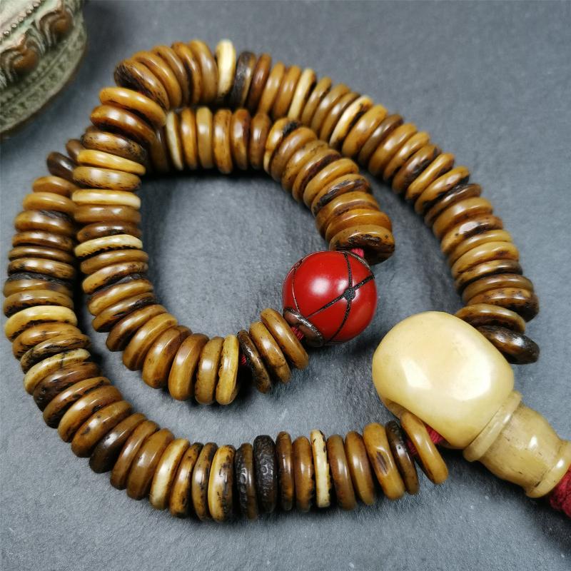 This bone carved mala beads is made by Tibetan craftsmen,about 30 years Old. It has 108 flat shape beads,1 red plastic spacer bead,and 1 yak bone guru bead,all hand carved,diameter is 12mm and perimeter is 15".
