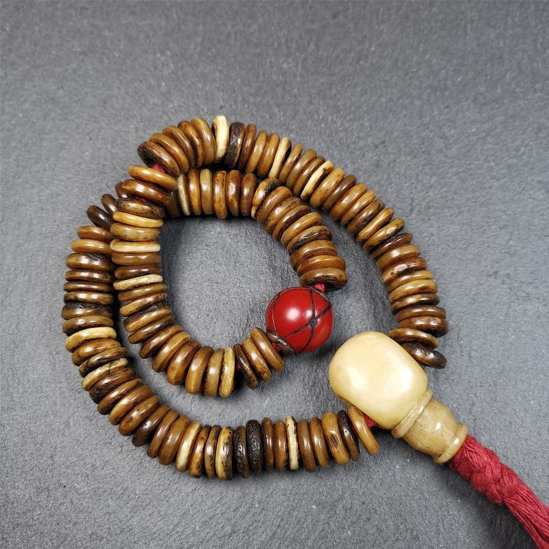 This bone carved mala beads is made by Tibetan craftsmen,about 30 years Old. It has 108 flat shape beads,1 red plastic spacer bead,and 1 yak bone guru bead,all hand carved,diameter is 12mm and perimeter is 15".