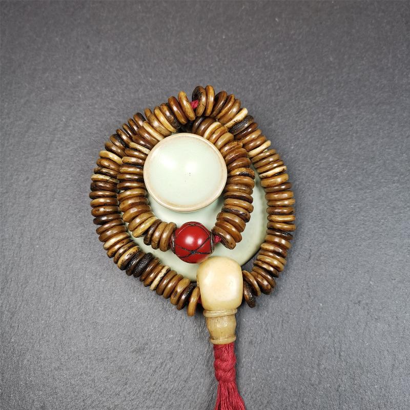 This bone carved mala beads is made by Tibetan craftsmen,about 30 years Old. It has 108 flat shape beads,1 red plastic spacer bead,and 1 yak bone guru bead,all hand carved,diameter is 12mm and perimeter is 15".