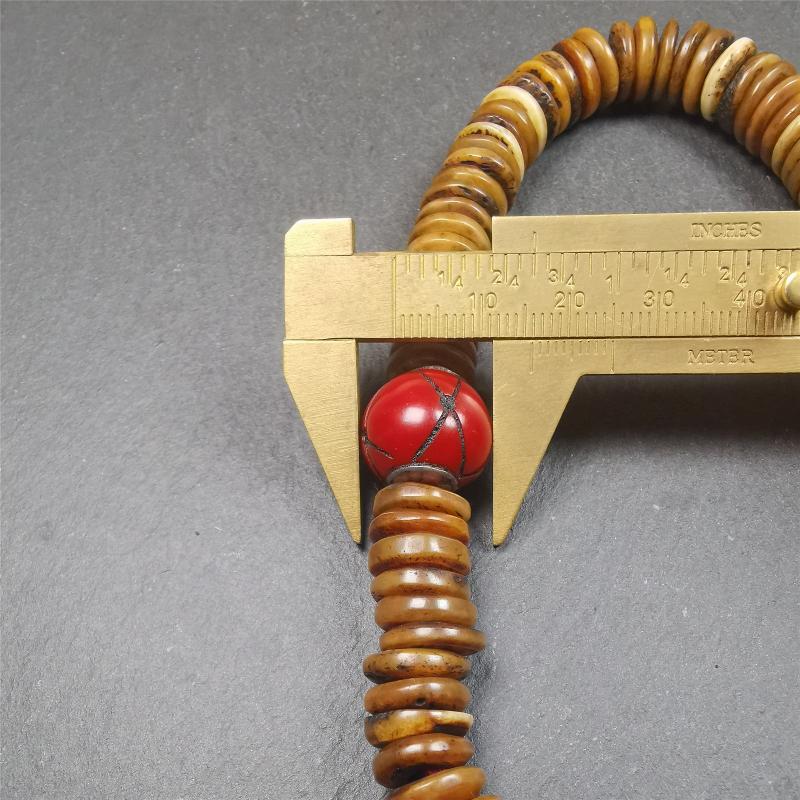 This bone carved mala beads is made by Tibetan craftsmen,about 30 years Old. It has 108 flat shape beads,1 red plastic spacer bead,and 1 yak bone guru bead,all hand carved,diameter is 12mm and perimeter is 15".