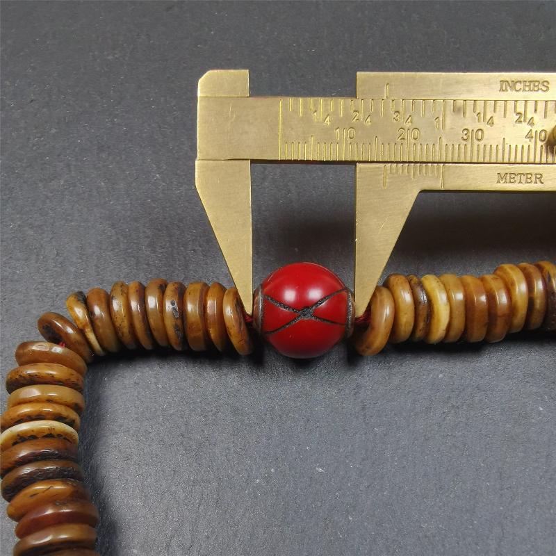This bone carved mala beads is made by Tibetan craftsmen,about 30 years Old. It has 108 flat shape beads,1 red plastic spacer bead,and 1 yak bone guru bead,all hand carved,diameter is 12mm and perimeter is 15".