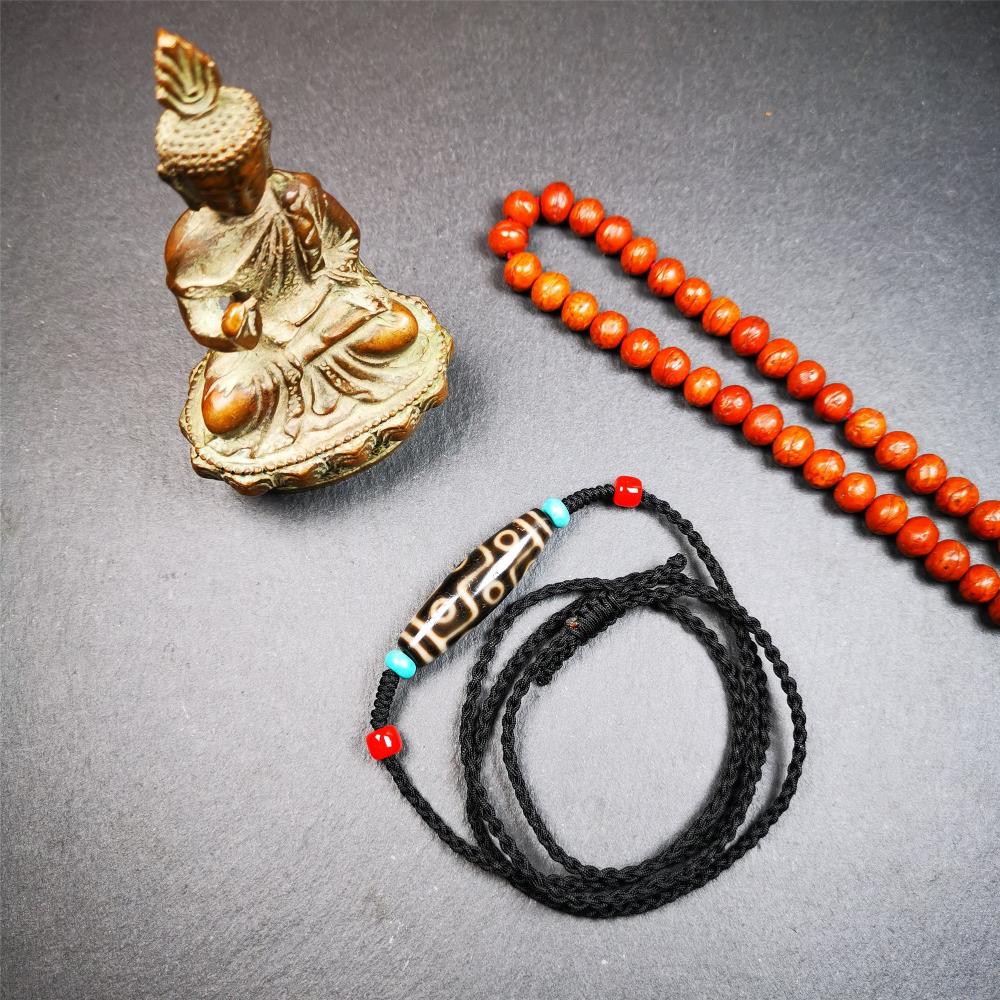 This 9 eyes dzi bead was collected from gerze Tibet,about 40 years old. The necklace was hand-woven by Tibetans from Baiyu County, the main bead is a brown color 9 eyes dzi, paired with 2 turquoise beads and 2 red agate beads.