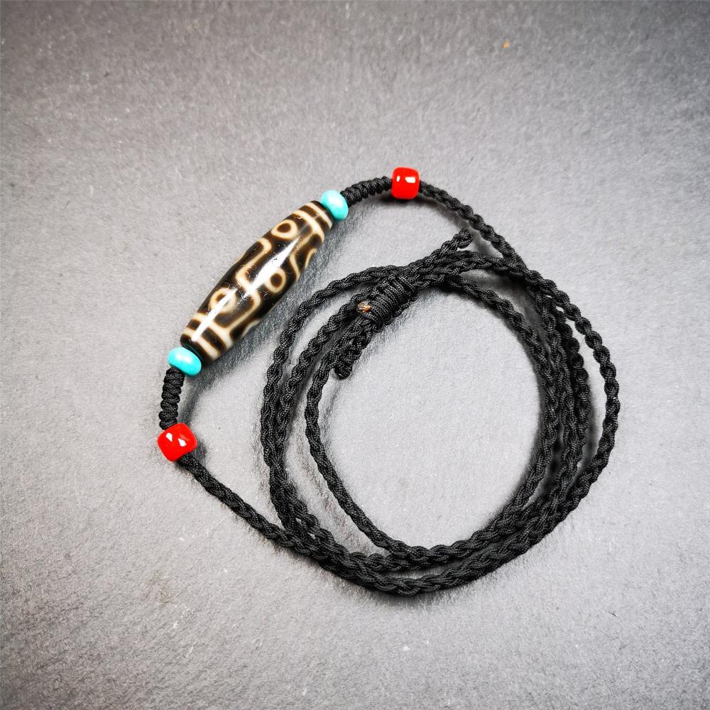 This 9 eyes dzi bead was collected from gerze Tibet,about 40 years old. The necklace was hand-woven by Tibetans from Baiyu County, the main bead is a brown color 9 eyes dzi, paired with 2 turquoise beads and 2 red agate beads.