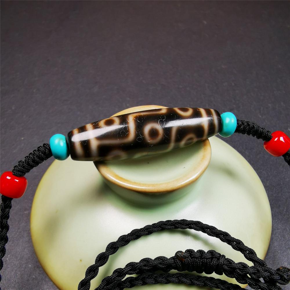 This 9 eyes dzi bead was collected from gerze Tibet,about 40 years old. The necklace was hand-woven by Tibetans from Baiyu County, the main bead is a brown color 9 eyes dzi, paired with 2 turquoise beads and 2 red agate beads.