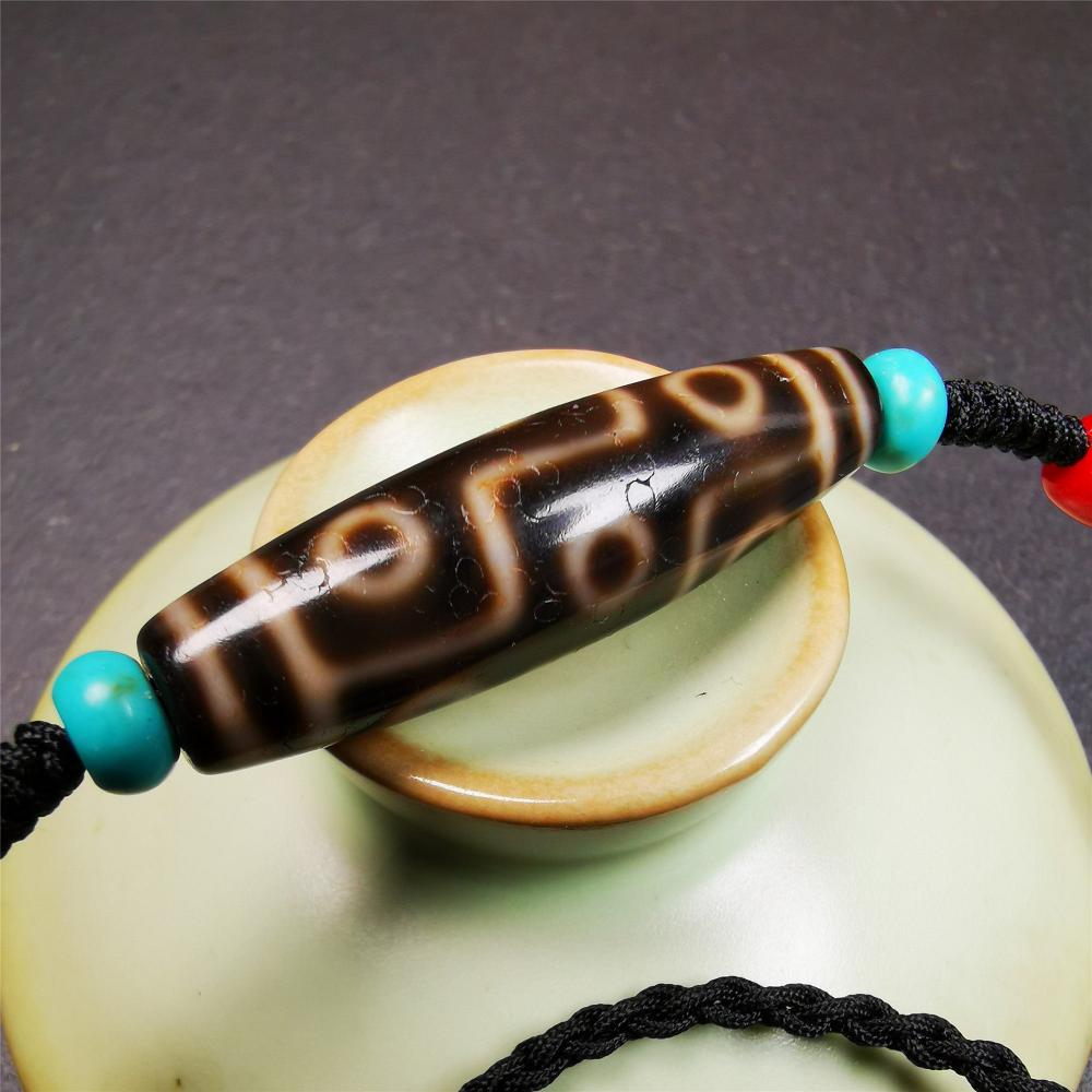 This 9 eyes dzi bead was collected from gerze Tibet,about 40 years old. The necklace was hand-woven by Tibetans from Baiyu County, the main bead is a brown color 9 eyes dzi, paired with 2 turquoise beads and 2 red agate beads.