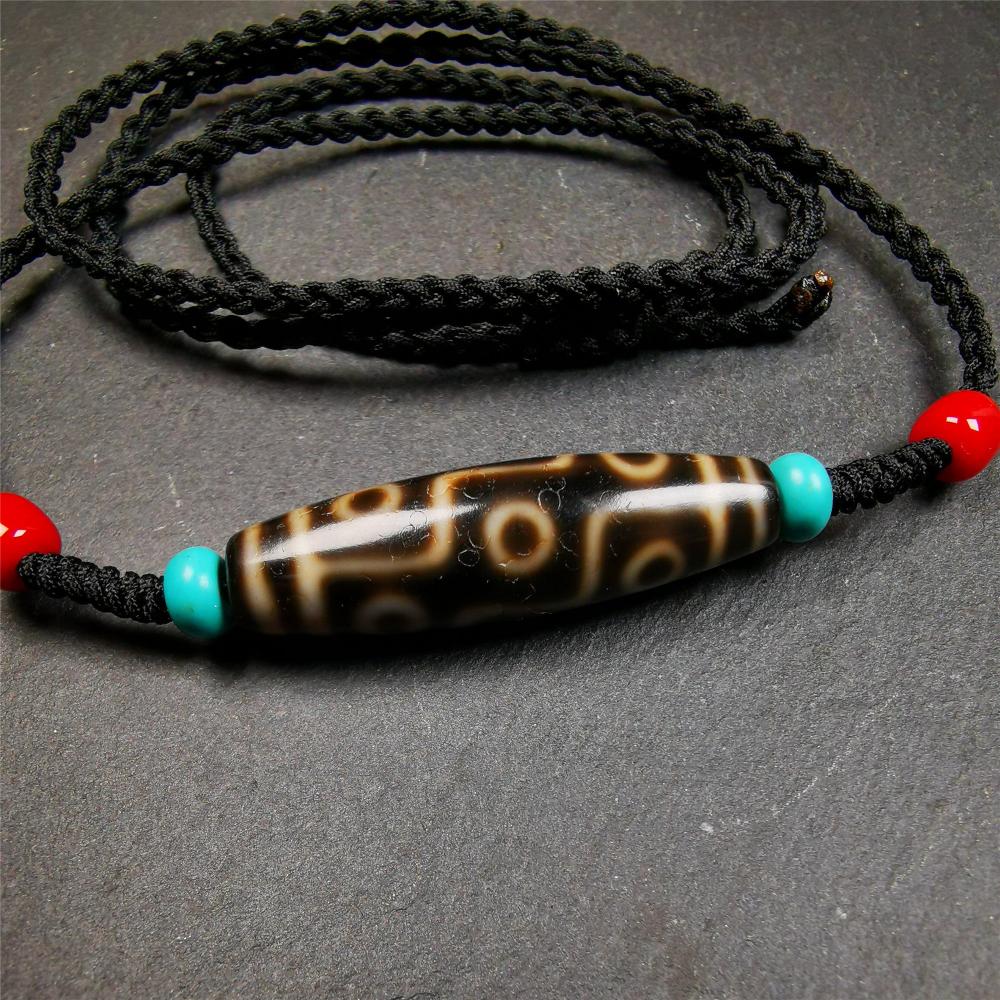 This 9 eyes dzi bead was collected from gerze Tibet,about 40 years old. The necklace was hand-woven by Tibetans from Baiyu County, the main bead is a brown color 9 eyes dzi, paired with 2 turquoise beads and 2 red agate beads.