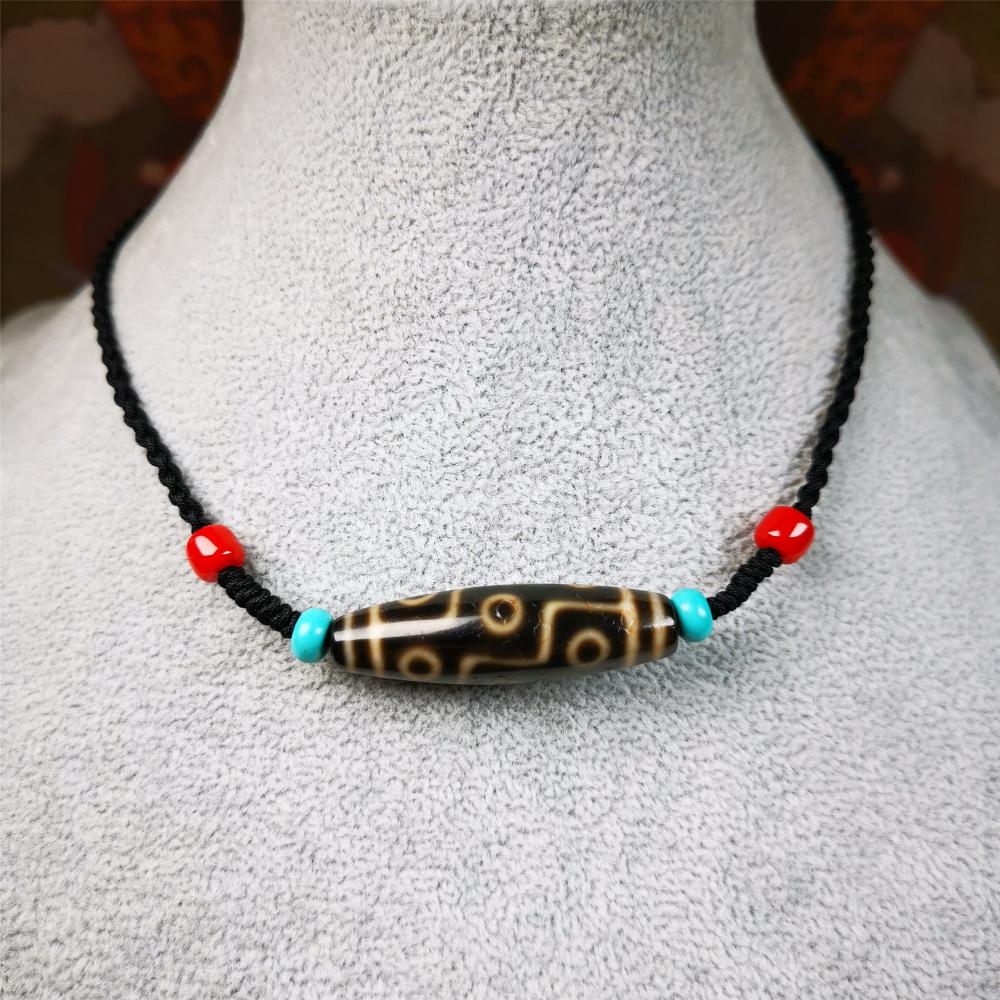 This 9 eyes dzi bead was collected from gerze Tibet,about 40 years old. The necklace was hand-woven by Tibetans from Baiyu County, the main bead is a brown color 9 eyes dzi, paired with 2 turquoise beads and 2 red agate beads.