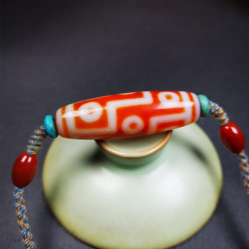 This necklace was hand-woven by Tibetans from Baiyu County, the main bead is a fire agate 9 eyes dzi, paired with 2 turquoise beads and 2 red agate beads,about 30 years old. The length of the necklace can be adjusted, the maximum circumference is about 60cm.