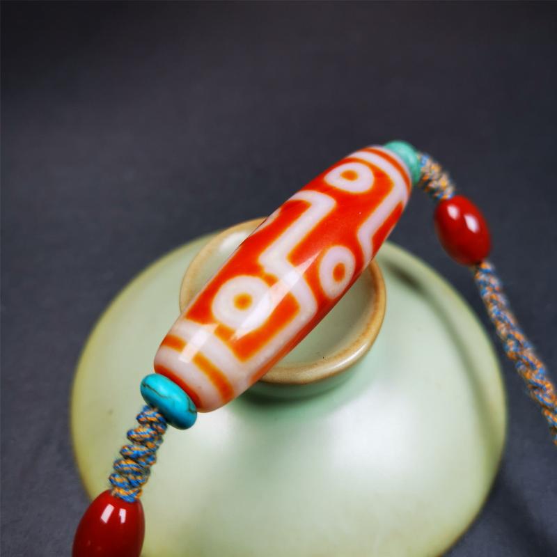 This necklace was hand-woven by Tibetans from Baiyu County, the main bead is a fire agate 9 eyes dzi, paired with 2 turquoise beads and 2 red agate beads,about 30 years old. The length of the necklace can be adjusted, the maximum circumference is about 60cm.