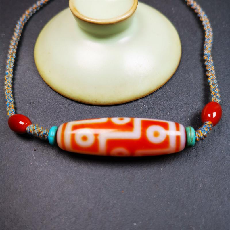 This necklace was hand-woven by Tibetans from Baiyu County, the main bead is a fire agate 9 eyes dzi, paired with 2 turquoise beads and 2 red agate beads,about 30 years old. The length of the necklace can be adjusted, the maximum circumference is about 60cm.