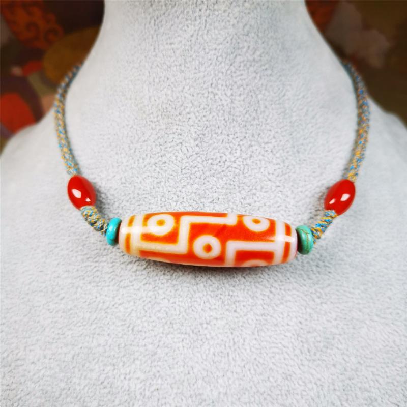 This necklace was hand-woven by Tibetans from Baiyu County, the main bead is a fire agate 9 eyes dzi, paired with 2 turquoise beads and 2 red agate beads,about 30 years old. The length of the necklace can be adjusted, the maximum circumference is about 60cm.